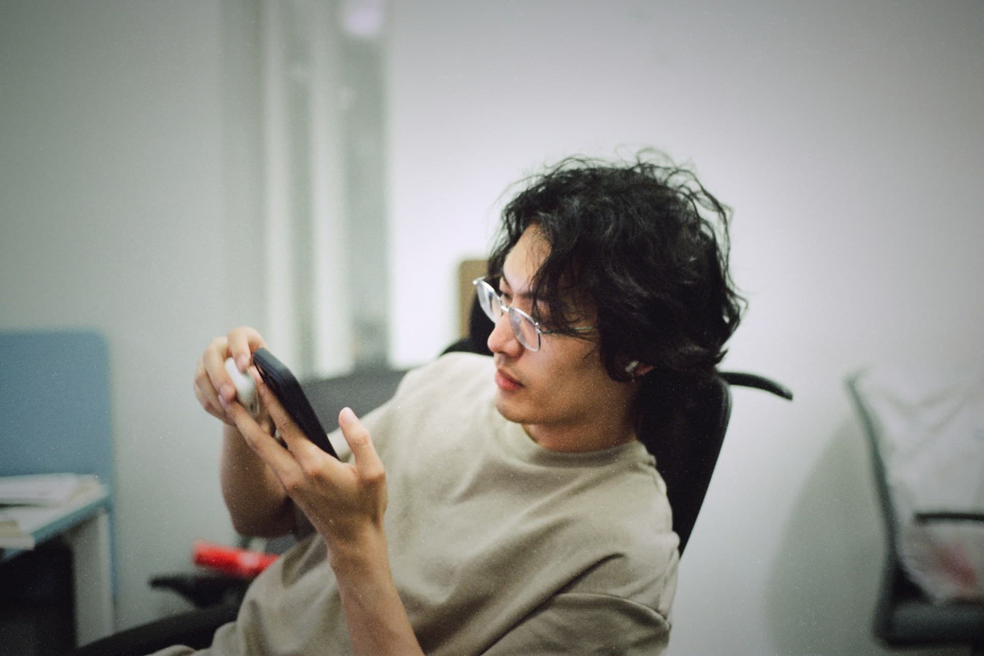 Mateo looking at his phone at the office